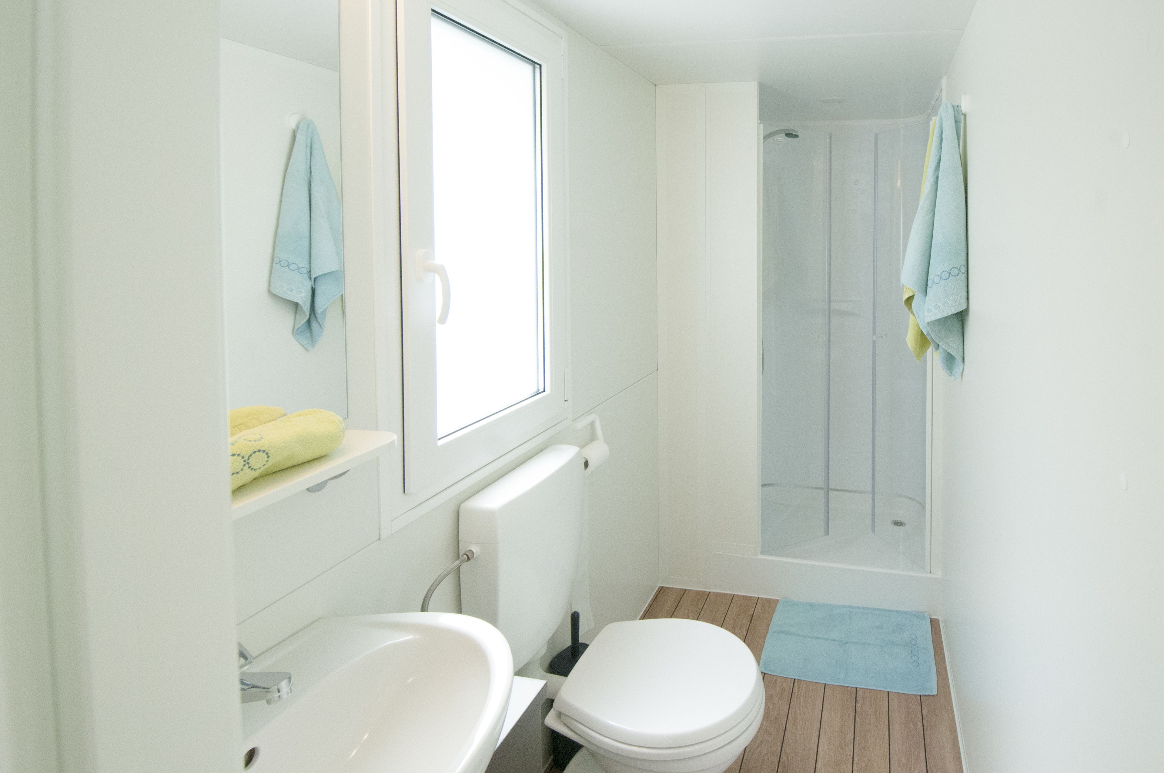 A bathroom with a toilet, sink, and shower.