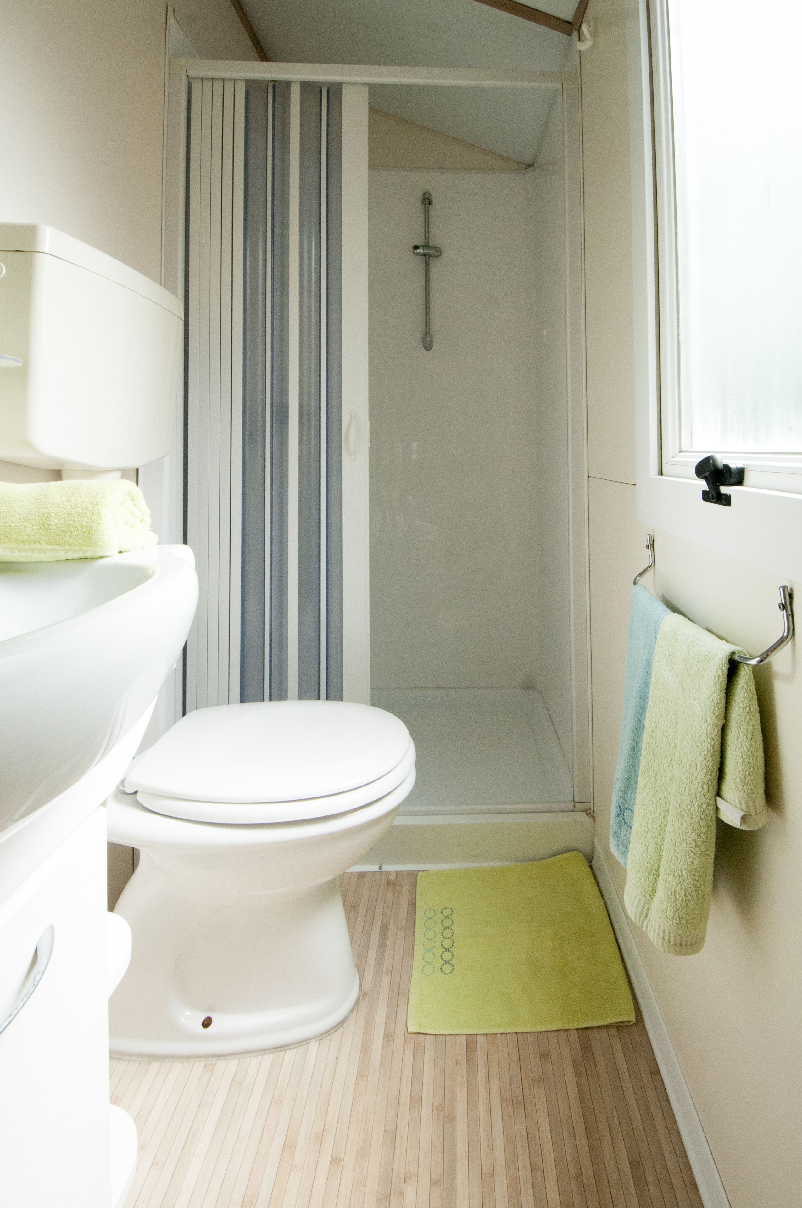 Ein Badezimmer mit Toilette, Dusche und Fenster.