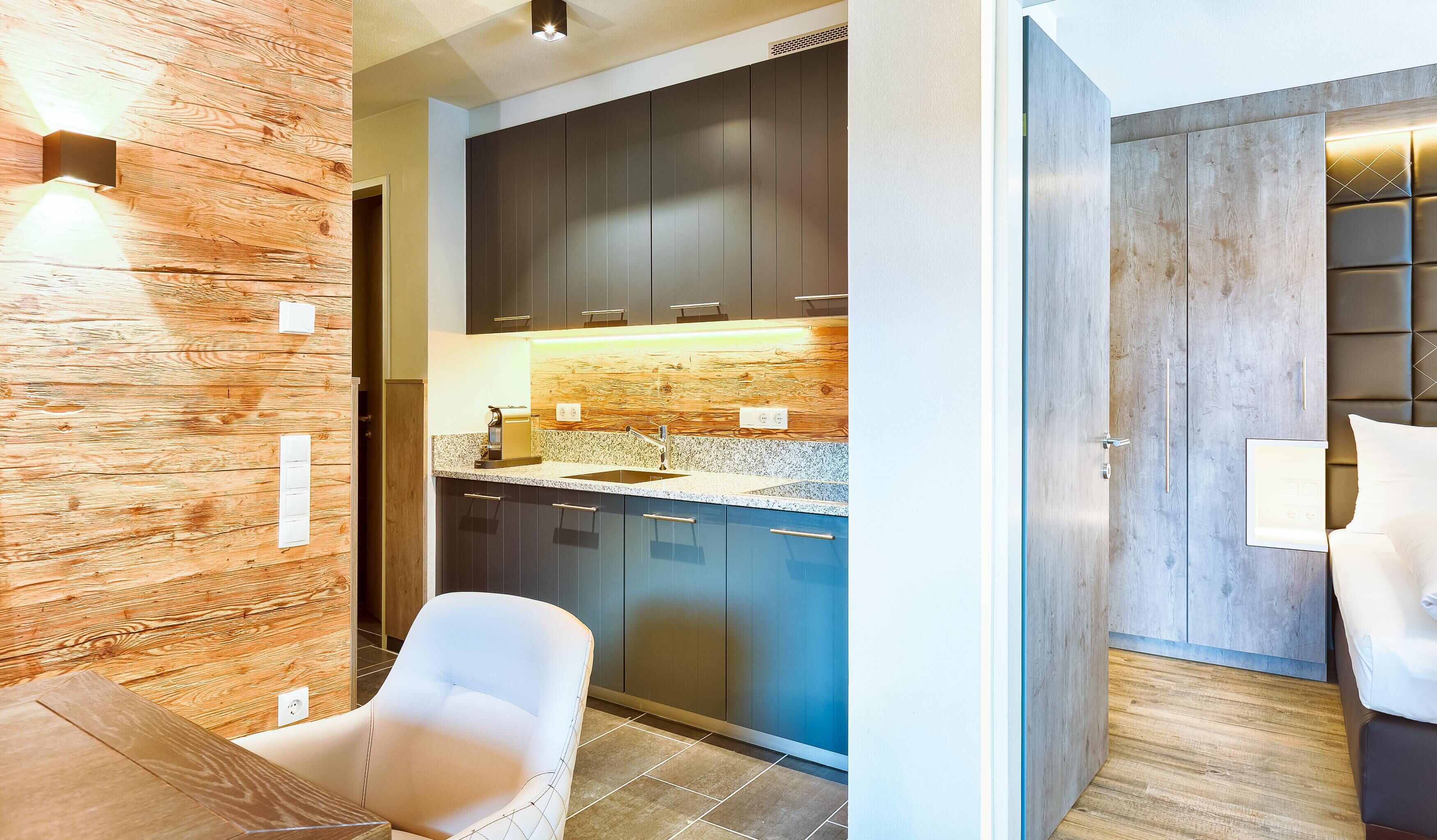 A modern kitchen with dark cabinets, a granite countertop, and a built-in oven.