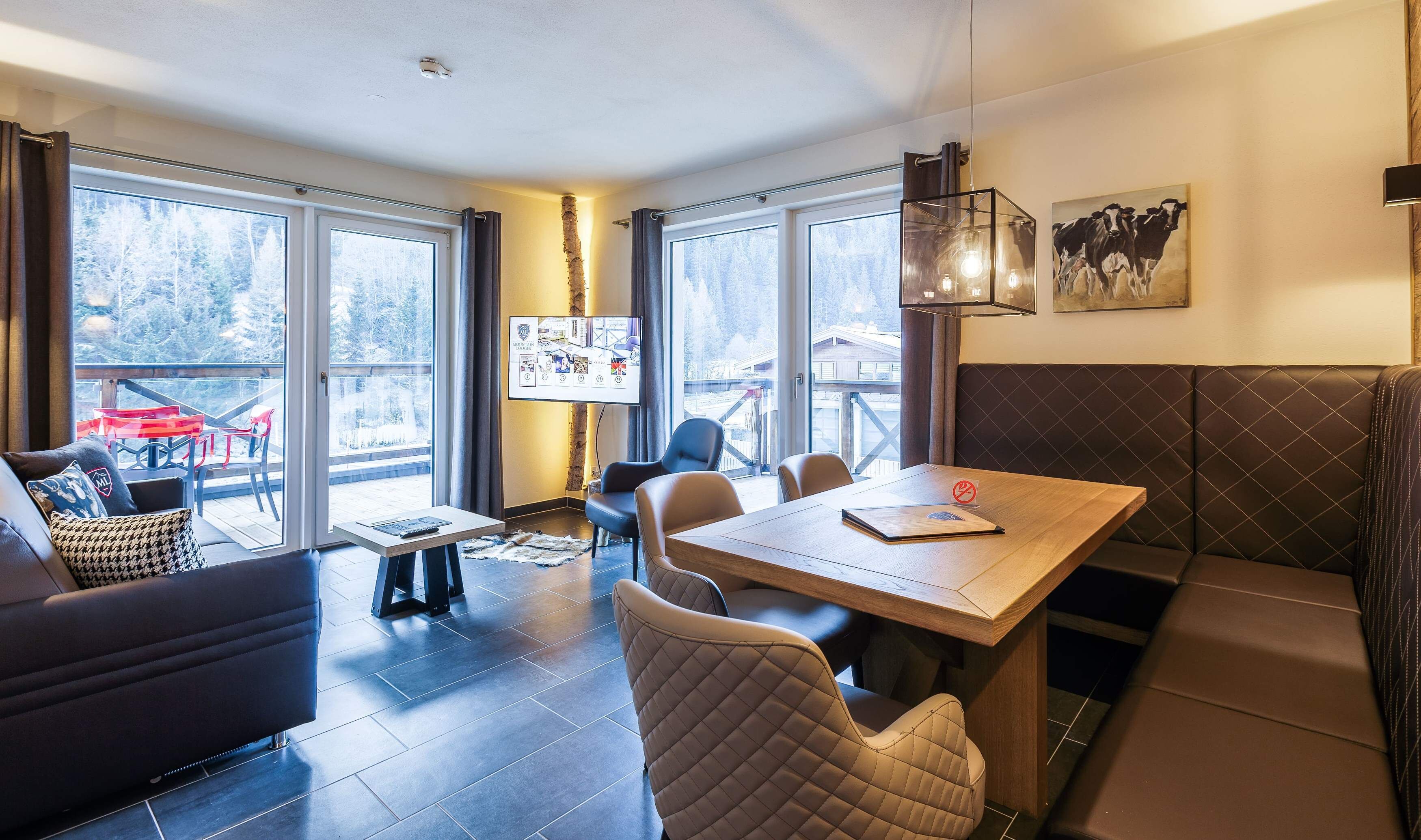 Een modern interieur met een groot raam, een houten tafel en een zithoek.
