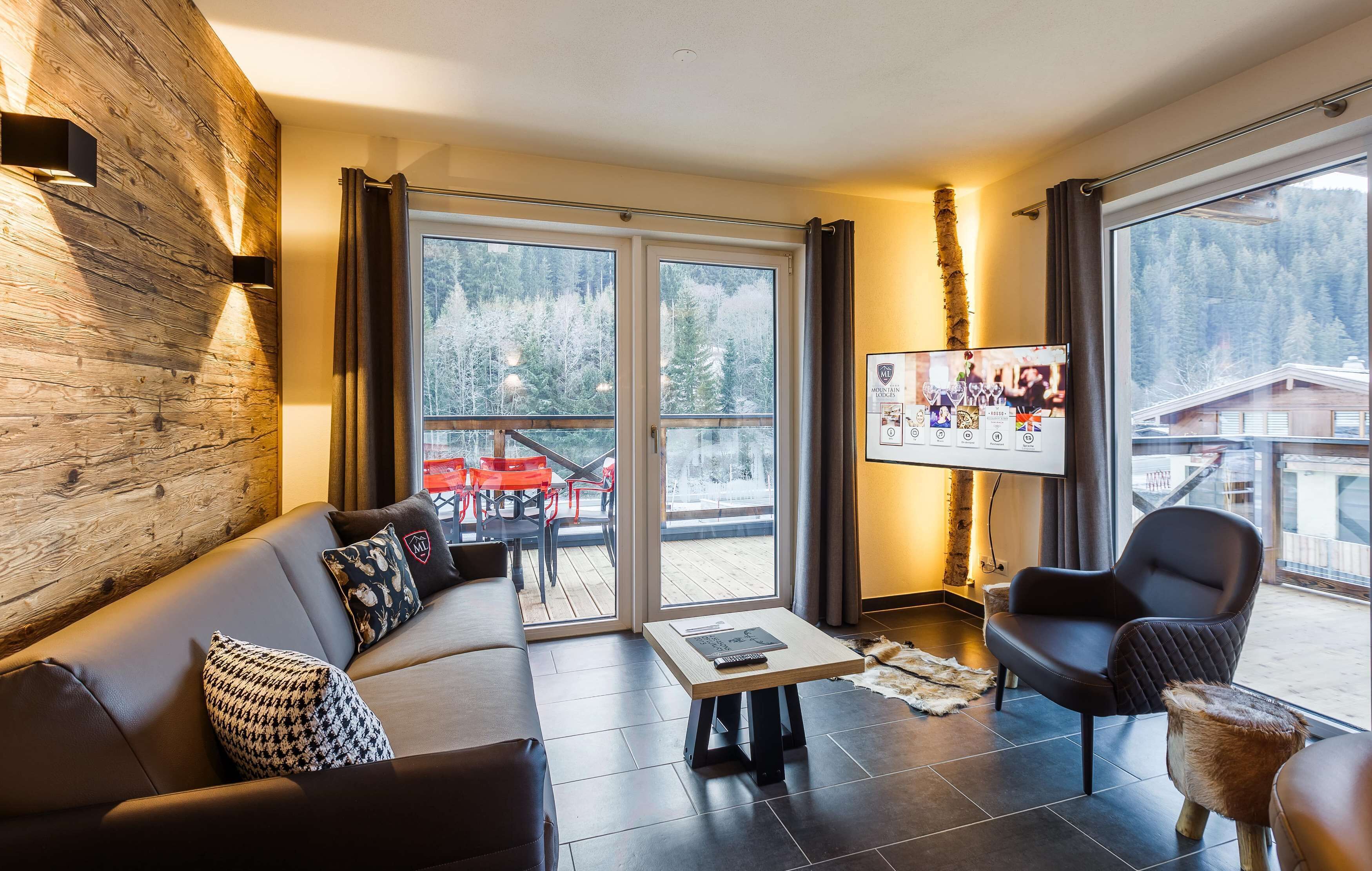 A modern living room with a wooden accent wall, a sofa, a coffee table, and a chair.