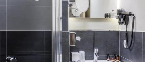A modern bathroom with a shower, a sink, and a mirror.