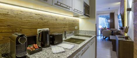 A modern kitchen with granite countertops, stainless steel appliances, and a wooden backsplash.