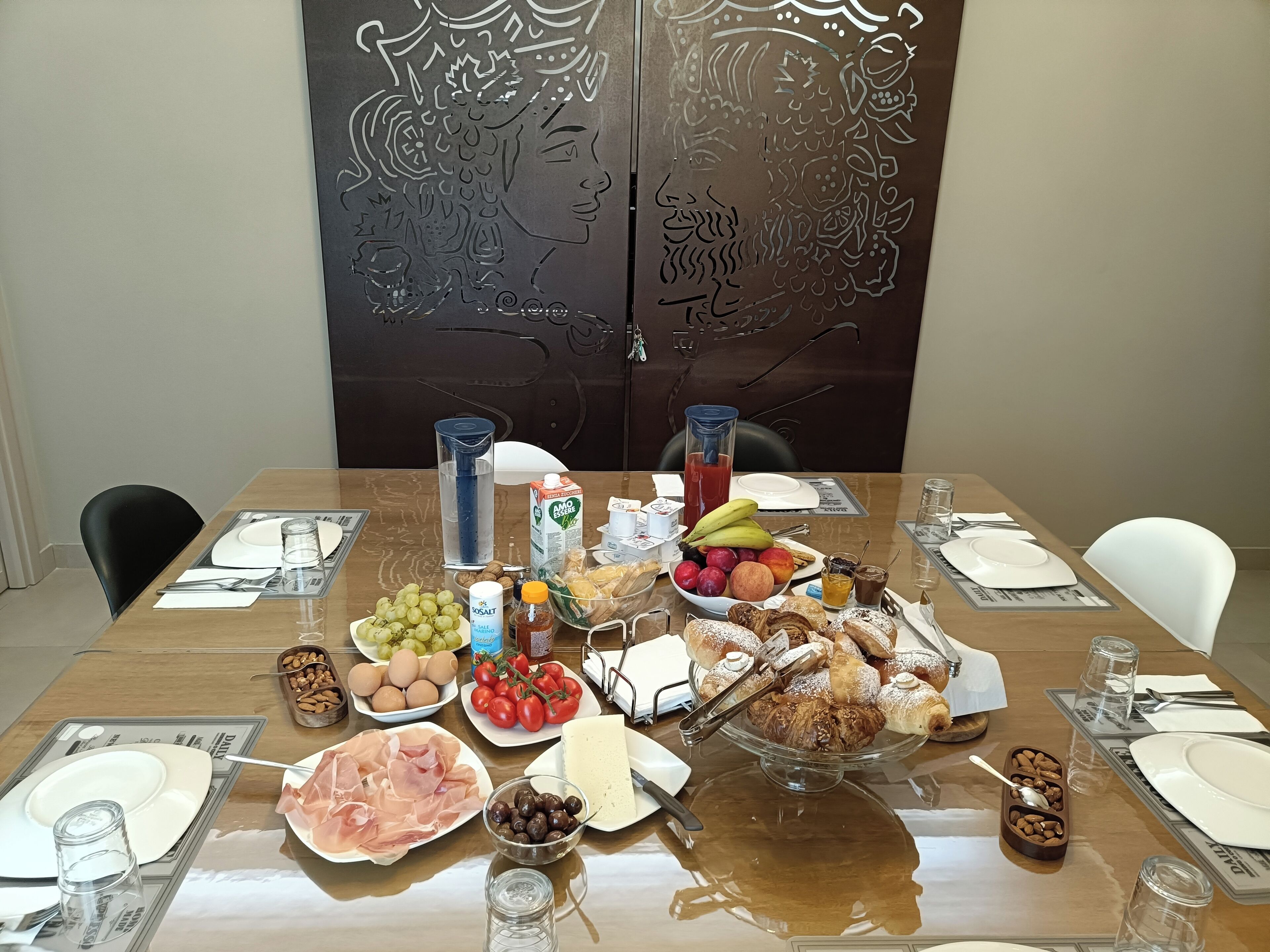 A dining table set with various food items, plates, and cutlery.