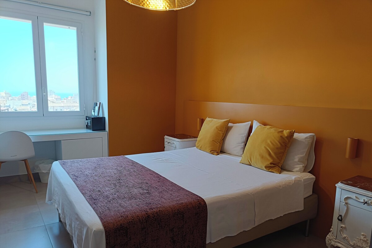 A bedroom with a bed, a desk, and a chair.