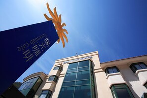 A building with large windows and a blue sign with gold text. - Hoya Resort Hotel Wuling (Taichung)