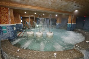 A hot tub with multiple jets, surrounded by mosaic tile walls and wooden beams. - Hoya Resort Hotel Wuling (Taichung)