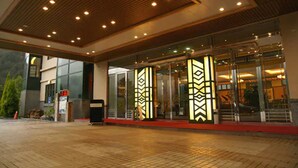 Ein Hotel mit modernem Design, dessen Eingang durch eine Glasfassade und ein geometrisches Muster gekennzeichnet ist.