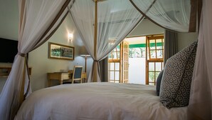 A bedroom with a bed, a desk, and a chair. - York Lodge (Harare)