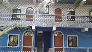 A two-story building with a patterned facade, multiple windows, and a central staircase.