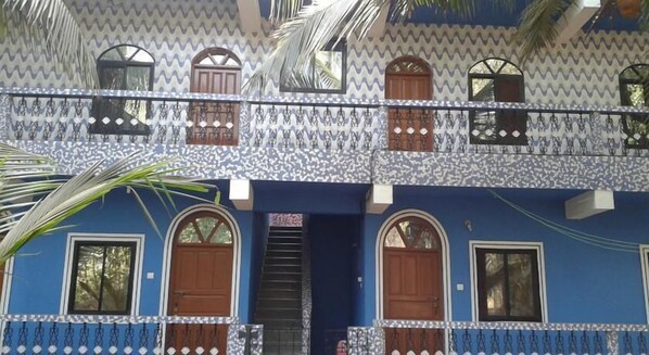 A two-story building with a patterned facade, multiple windows, and a central staircase.