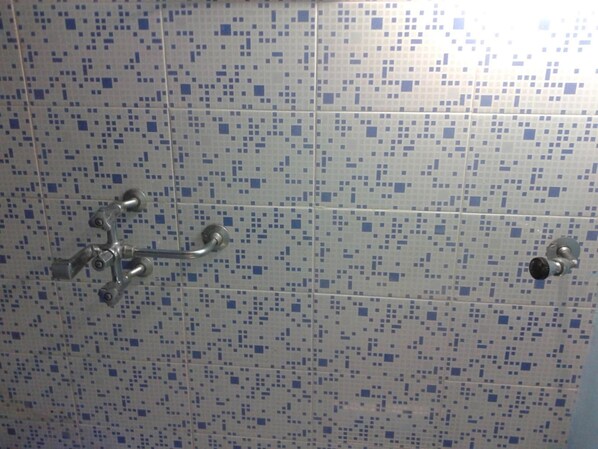 A tiled shower area with a mosaic pattern.