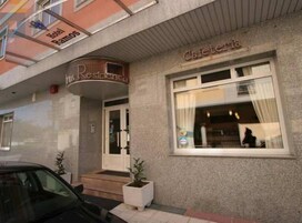 A hotel entrance with a sign reading "Hotel Ramoss Residencia" and a window with a sign "Cafeteria".