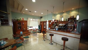 Un espace bar avec des tabourets, un comptoir et des étagères remplies de bouteilles.