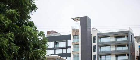 A multi-story building with a modern architectural design, featuring balconies and large windows.