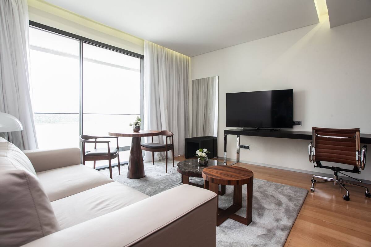A modern living room with a sofa, a coffee table, a TV, and a chair.