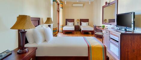 A hotel room with two beds, a TV, a desk, and a wardrobe.