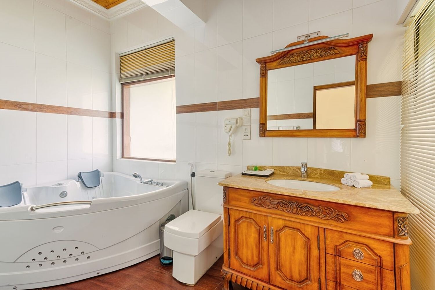 Ein Badezimmer mit einer freistehenden Badewanne, einem Waschtisch mit Spiegel und einer Toilette.