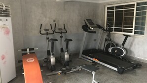 A home gym with a treadmill, elliptical, stationary bike, and weight bench. - Pentagon Luxury Suites Enugu (Enugu)