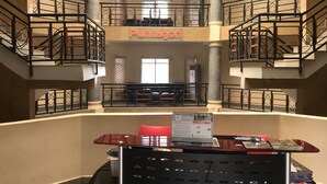 A multi-level atrium with a central staircase, a reception desk, and a sign reading "Pentagon". - Pentagon Luxury Suites Enugu (Enugu)