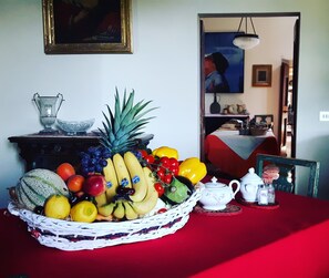 A dining table with a fruit basket, a white teapot, and salt and pepper shakers. - Bella di Ceciliano (Arezzo)