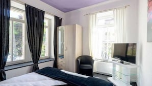 Une chambre à coucher avec un lit, une télévision, un bureau et une chaise.