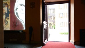 Une porte ouverte donnant sur une rue, avec un bâtiment portant l’inscription « ZUGWIL ».