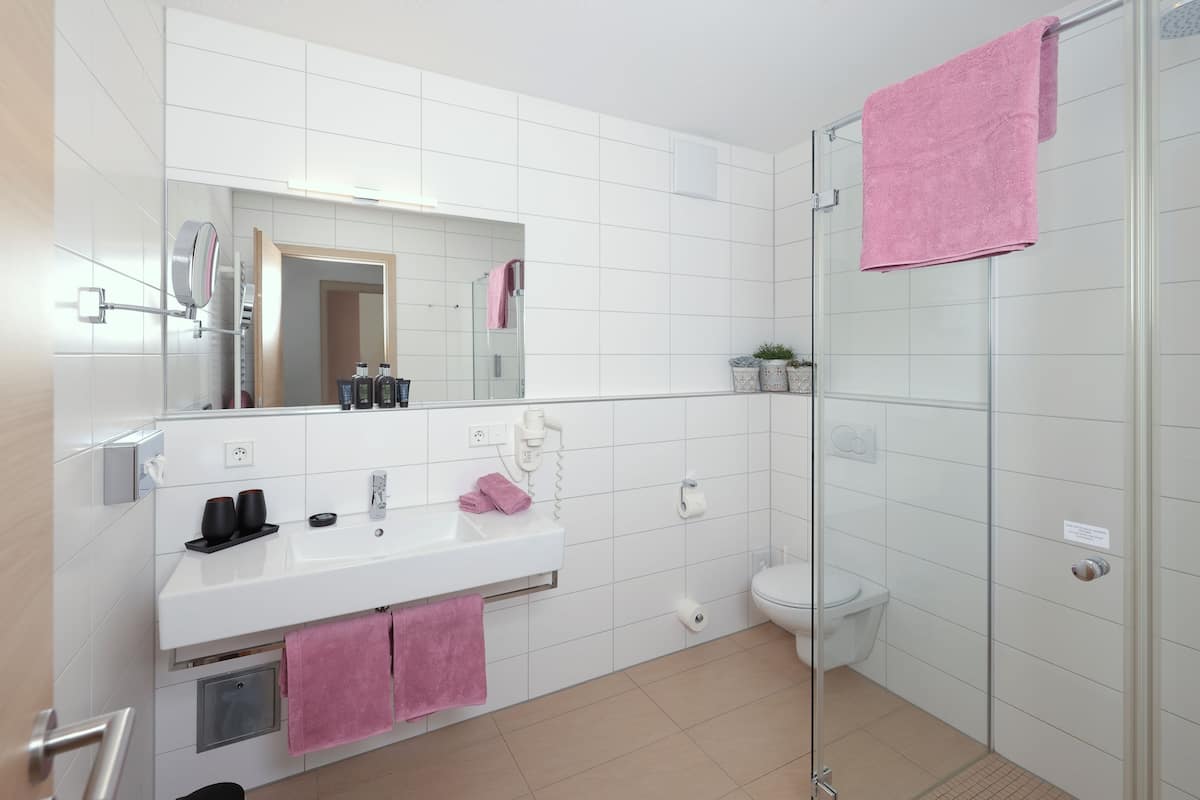 Ein modernes Badezimmer mit Waschbecken, Spiegel und Duschkabine aus Glas.