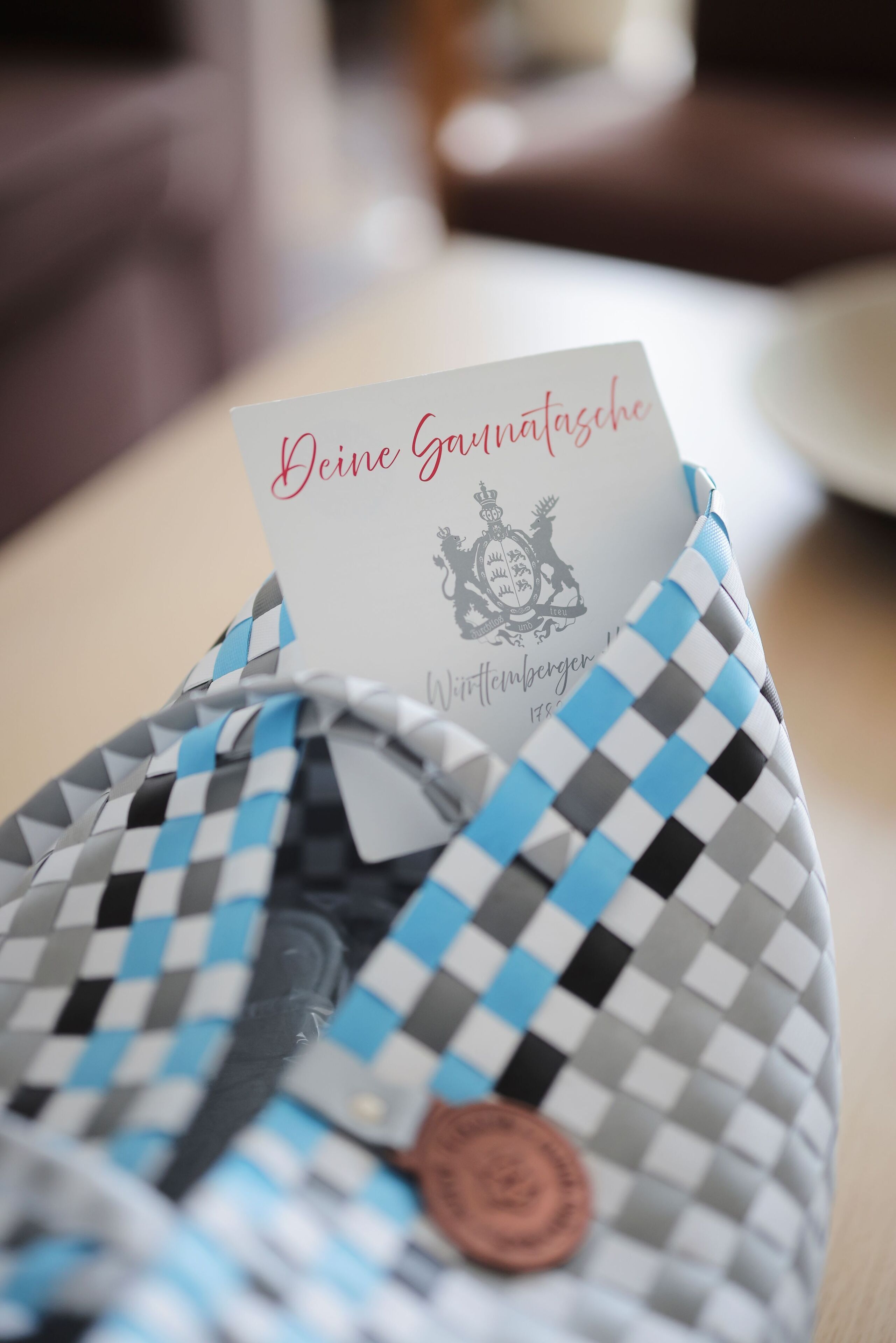 Un sac à carreaux avec une étiquette portant l’inscription « Deine Garnitase » et un blason.
