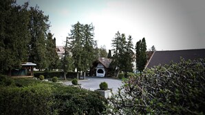 A landscaped garden with a gazebo, a small building with a sloped roof, and a paved pathway. - Hotel Park Sfantu Gheorghe (Sfantu Gheorghe (Transylvania))