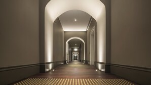 A long, narrow hallway with a series of arches and a wooden floor. - COMO The Treasury (Perth)