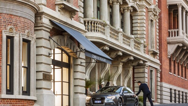 A black car parked in front of a building with a sign reading "COMMITTEE OF THE TREASURY". - COMO The Treasury (Perth)