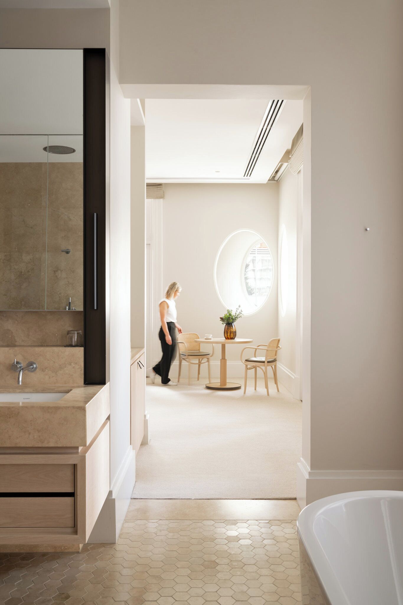 Une salle de bain moderne dotée d’une grande baignoire, d’un espace douche et d’un meuble-lavabo avec un miroir.