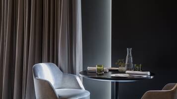 A modern dining area with a round table, a chair, and a vase.