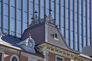 A building with a classic architectural style, featuring ornate metalwork on the roof and a prominent circular window.