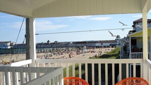 A beach view from a porch with white railings and orange chairs. - Copley LaReine Motel (Old Orchard Beach)