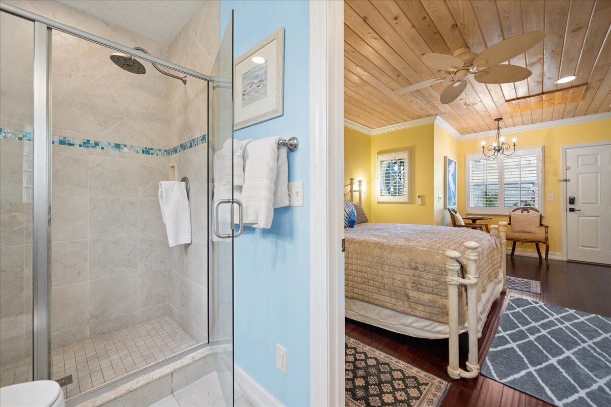 Une salle de bain avec une douche à parois de verre, des toilettes et un porte-serviettes.