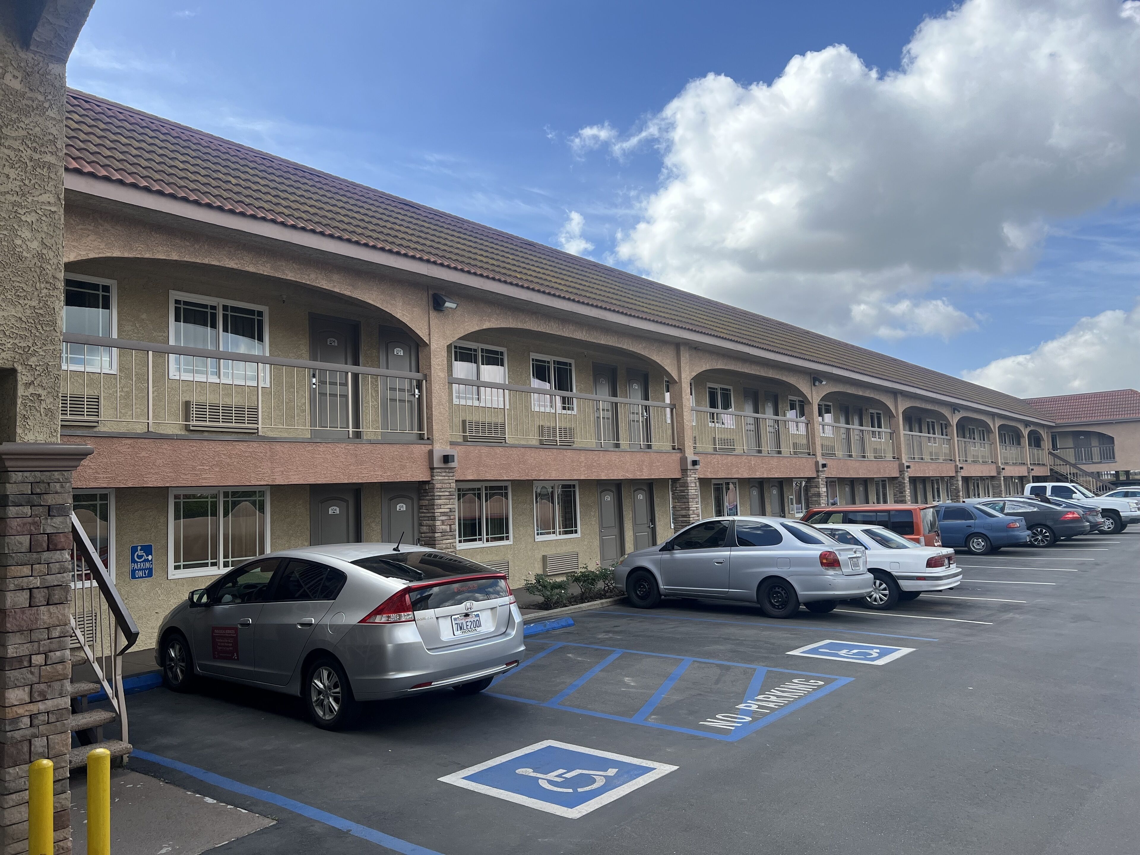 Un motel de varios pisos con estacionamiento.