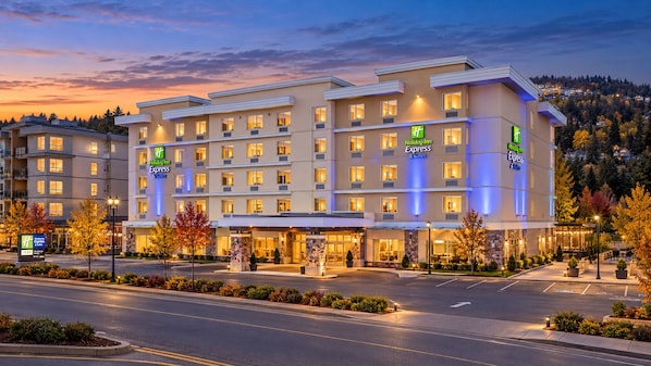 A multi-story Holiday Inn Express hotel with a well-lit entrance and a view of the surrounding area.