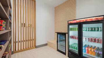 Un intérieur propre et moderne, avec des distributeurs automatiques, des étagères remplies d’en-cas et une cloison en bois.