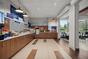 Una cocina moderna con barra desayunadora, armarios de madera y vistas al exterior.