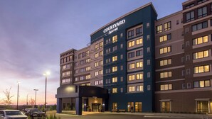 A Courtyard by Marriott hotel with a modern design, multiple floors, and a well-lit entrance. - Courtyard by Marriott Calgary South (Calgary)