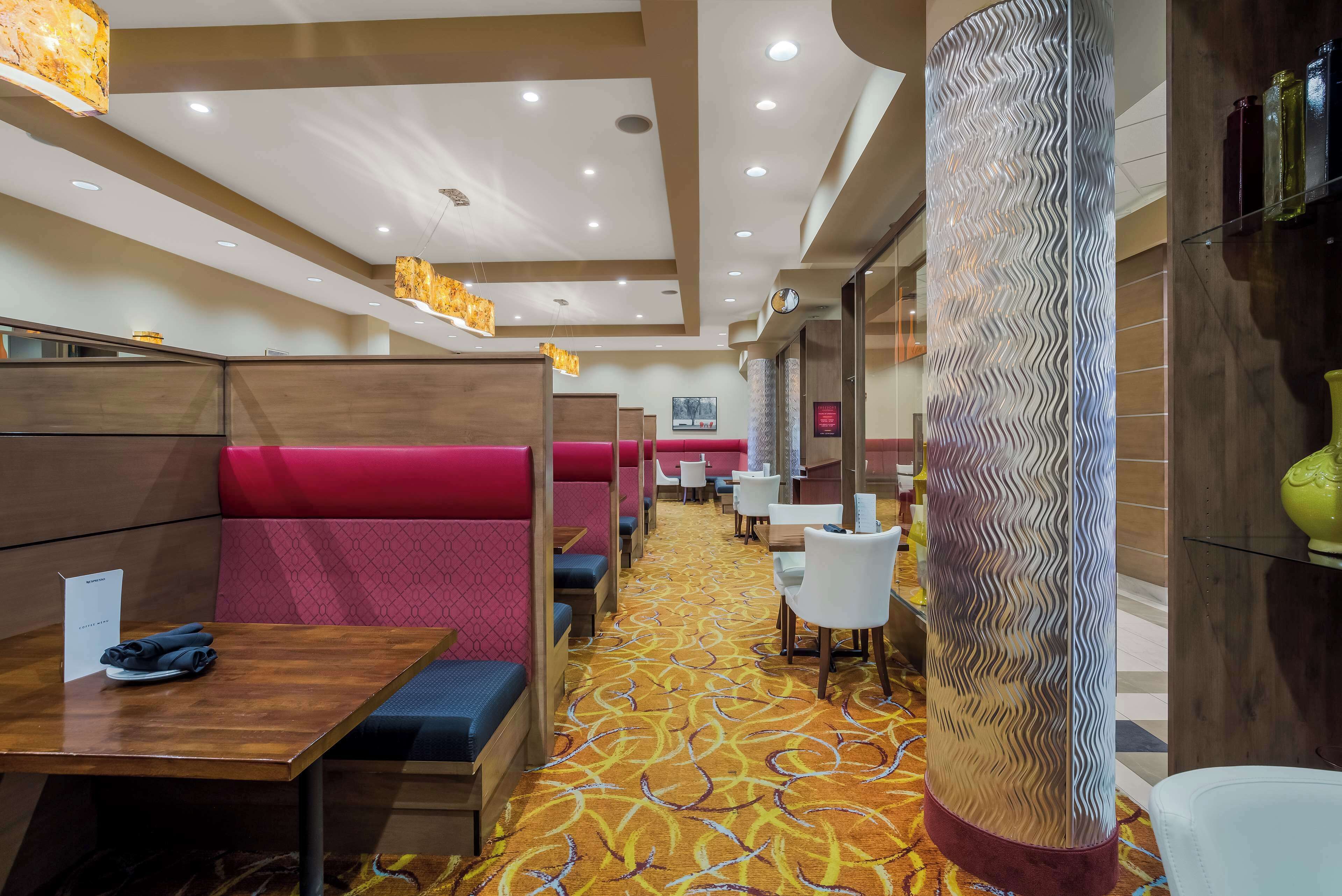 Un restaurante con cabinas, mesas y una alfombra estampada.