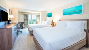A hotel room with two beds, a desk with a TV, and a chair. There are two paintings on the wall. - Holiday Inn Express & Suites Nassau by IHG (Nassau)