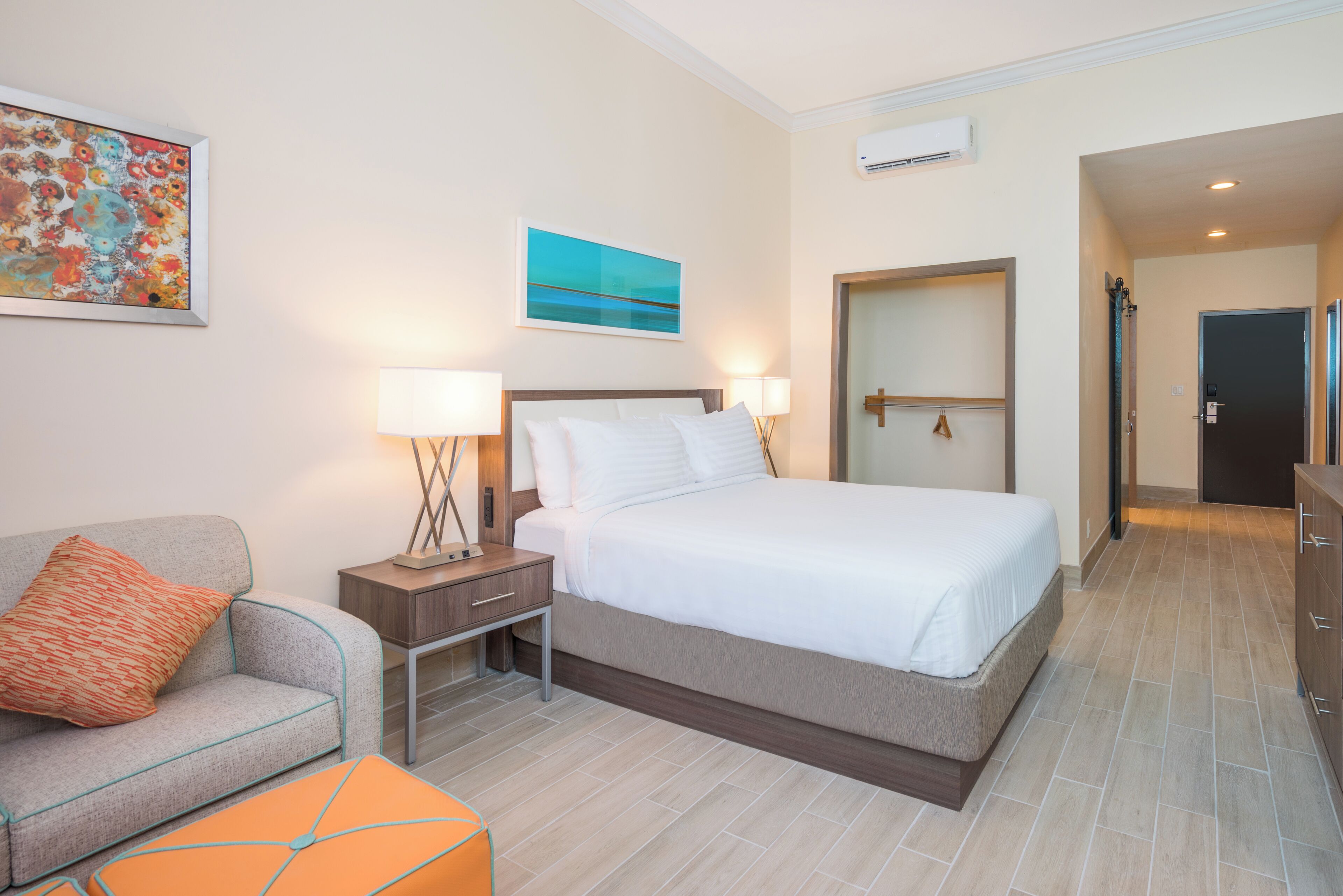 Une chambre d’hôtel avec un lit, une table de chevet, une lampe et un tableau au mur.