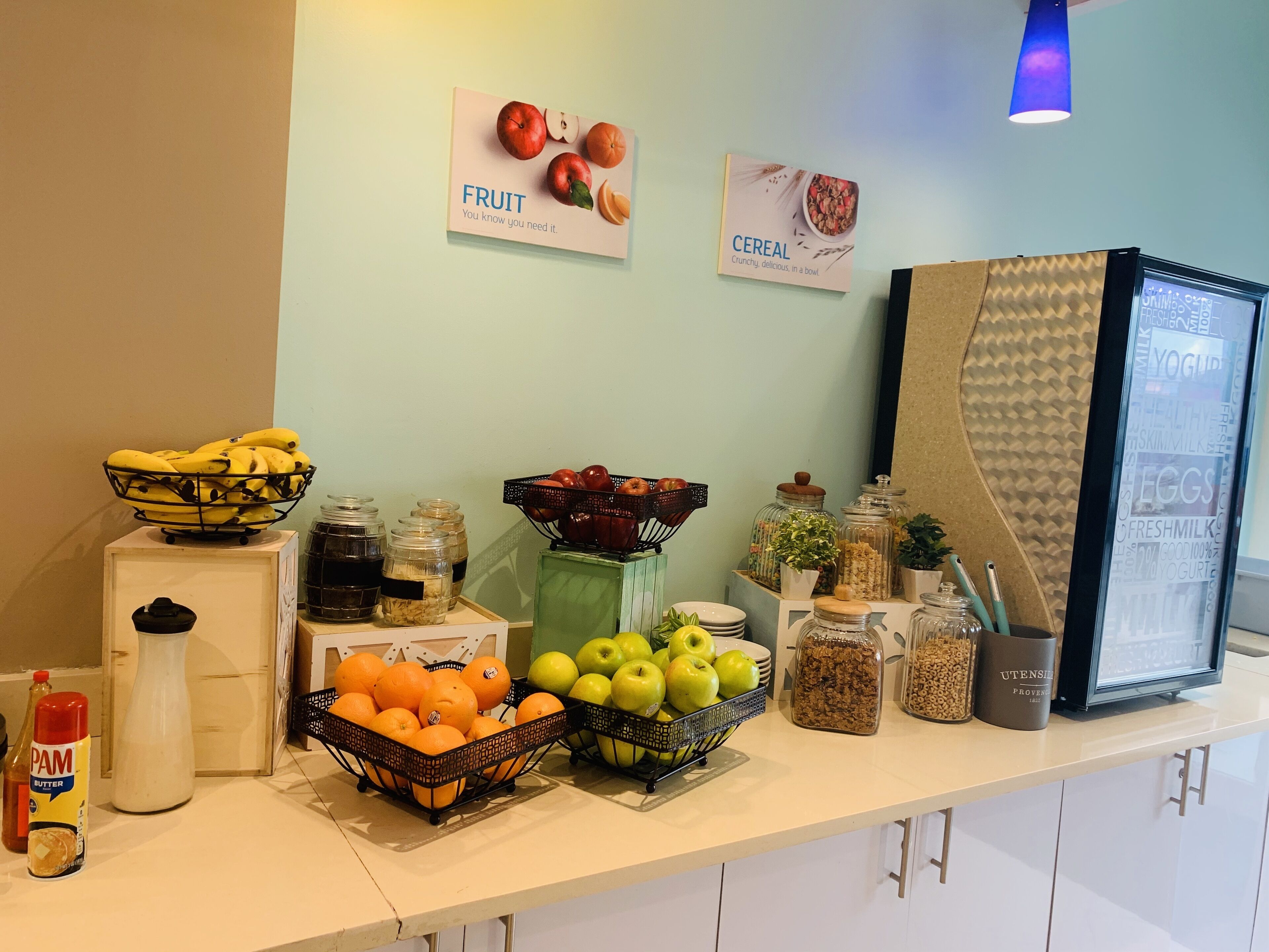 A breakfast buffet with various fruits, cereals, and dairy products.