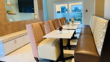 Un comedor moderno con una larga mesa y asientos acolchados.