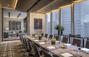 A conference room with a long table, chairs, and a large window.