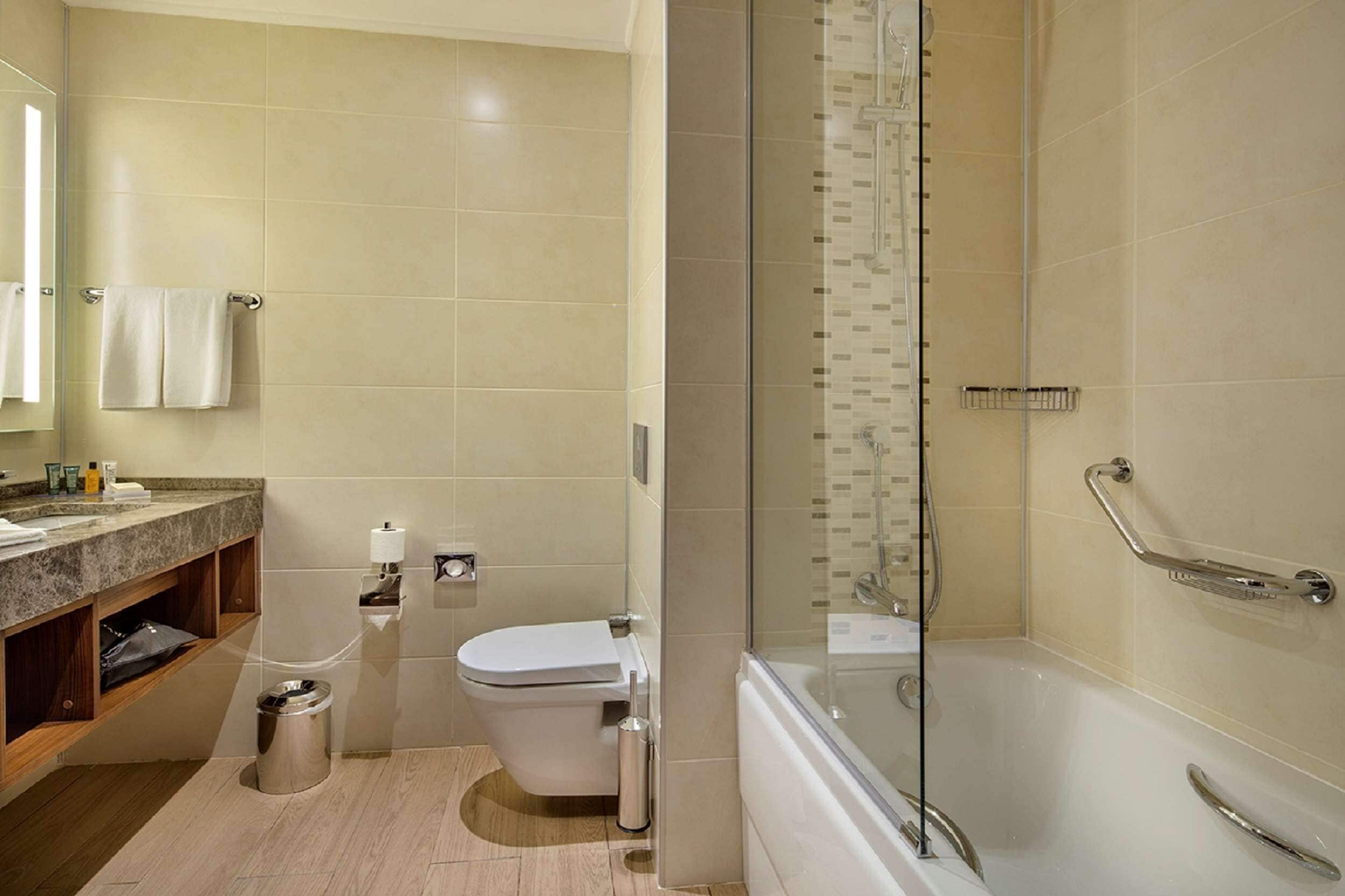 A modern bathroom with a toilet, sink, and shower.