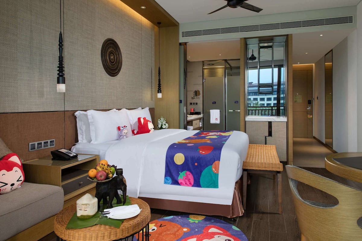 Relax in a stylish room with a large bed, sofa, and ceiling fan.